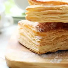 Puszyste ciasto francuskie, idealne do przygotowania według prostego przepisu. Posypane cukrem pudrem, czeka na swoją kolej.