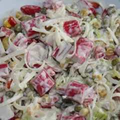Pyszna sałatka z surimi, groszkiem, kukurydzą i warzywami, polana kremowym sosem. Idealna na każdą okazję.