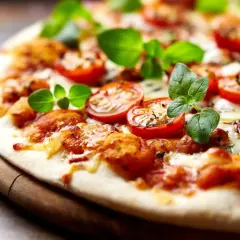 Pyszna pizza bez drożdży z pomidorkami koktajlowymi i świeżą bazylią, idealna na szybki obiad.