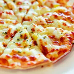 Pyszna, gorąca pizza z patelni, z ciągnącym się serem i ziołami, idealna na szybki obiad.