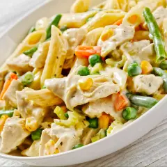 Penne z kurczakiem w kremowym sosie, z groszkiem, kukurydzą i fasolką szparagową. Pyszne danie obiadowe.