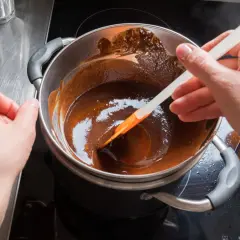 Delikatne mieszanie rozpuszczonej czekolady w kąpieli wodnej, by uzyskać idealną konsystencję. To prosty sposób, jak rozpuścić czekoladę.