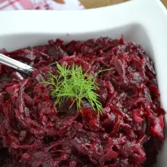 Pyszne, aromatyczne buraczki na ciepło, udekorowane gałązką koperku, podane w białej miseczce.