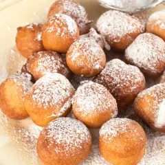Puszyste paczki z serka homo, posypane cukrem pudrem, kuszą swoim apetycznym wyglądem.