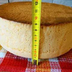 Idealny biszkopt na tort, zmierzony miarką, ma około 7 cm wysokości. Puszysty i złocisty, gotowy do dekoracji.