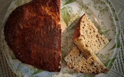 Pyszny chleb keto przepis na talerzu z konwaliami. Złocista skórka i puszysty środek.
