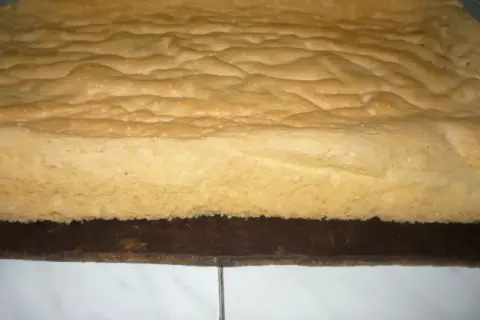 Puszysty biszkopt z 3 jaj, lekko zarumieniony, z charakterystyczną falistą powierzchnią, gotowy do dalszego dekorowania.
