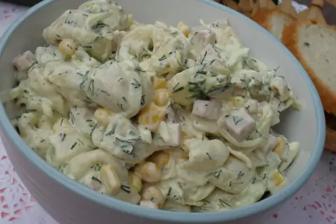 Pyszna sałatka z tortellini, kukurydzy, szynki i koperku w kremowym sosie. Idealna na letnie przyjęcie.