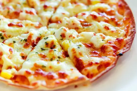 Pyszna, gorąca pizza z patelni, z ciągnącym się serem i ziołami, idealna na szybki obiad.