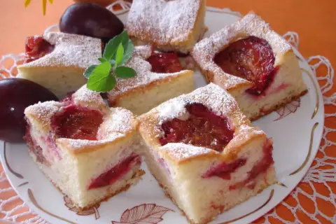 Szybkie ciasto ze śliwkami na oleju, posypane cukrem pudrem, wygląda apetycznie. Idealne na deser!