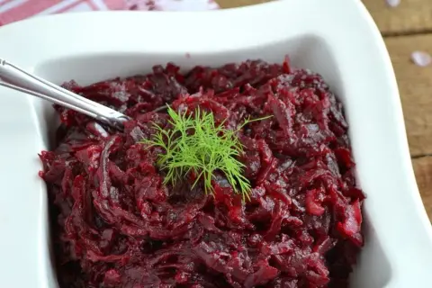 Pyszne, aromatyczne buraczki na ciepło, udekorowane gałązką koperku, podane w białej miseczce.