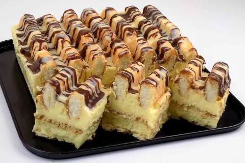 Pyszne ciasto góra lodowa z kremem i biszkoptami, polane czekoladą i białą polewą.