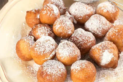 Puszyste paczki z serka homo, posypane cukrem pudrem, kuszą swoim apetycznym wyglądem.