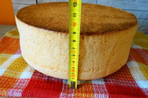 Idealny biszkopt na tort, zmierzony miarką, ma około 7 cm wysokości. Puszysty i złocisty, gotowy do dekoracji.