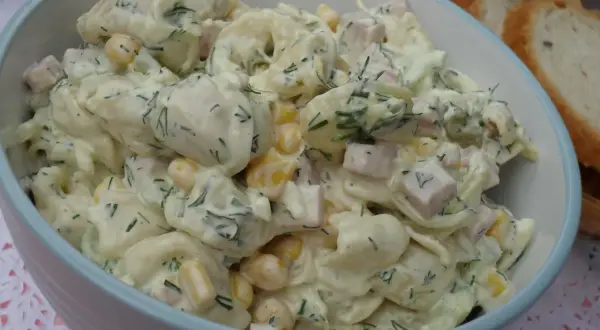 Pyszna sałatka z tortellini, kukurydzy, szynki i koperku w kremowym sosie. Idealna na letnie przyjęcie.
