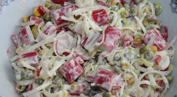 Pyszna sałatka z surimi, groszkiem, kukurydzą i warzywami, polana kremowym sosem. Idealna na każdą okazję.