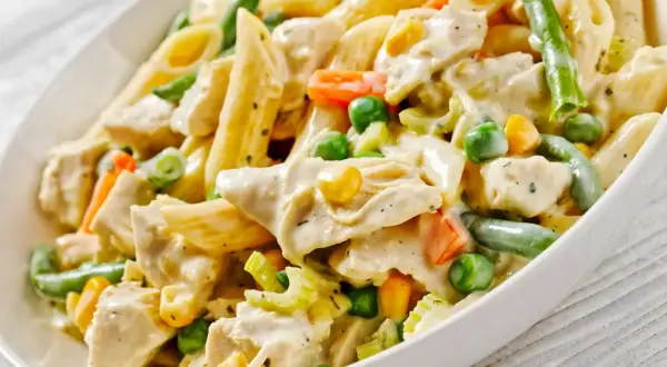Penne z kurczakiem w kremowym sosie, z groszkiem, kukurydzą i fasolką szparagową. Pyszne danie obiadowe.