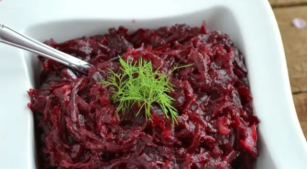Pyszne, aromatyczne buraczki na ciepło, udekorowane gałązką koperku, podane w białej miseczce.