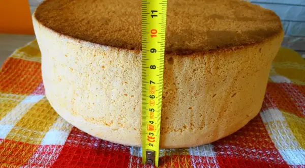 Idealny biszkopt na tort, zmierzony miarką, ma około 7 cm wysokości. Puszysty i złocisty, gotowy do dekoracji.