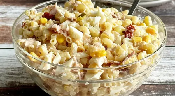 Pyszna sałatka z tuńczykiem i makaronem, jajkiem i kukurydzą w szklanej misce. Idealna na szybki obiad.