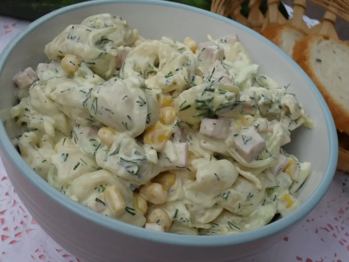 Pyszna sałatka z tortellini, kukurydzy, szynki i koperku w kremowym sosie. Idealna na letnie przyjęcie.