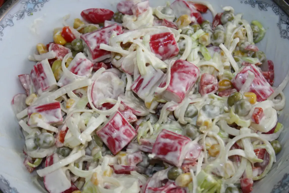 Pyszna sałatka z surimi, groszkiem, kukurydzą i warzywami, polana kremowym sosem. Idealna na każdą okazję.