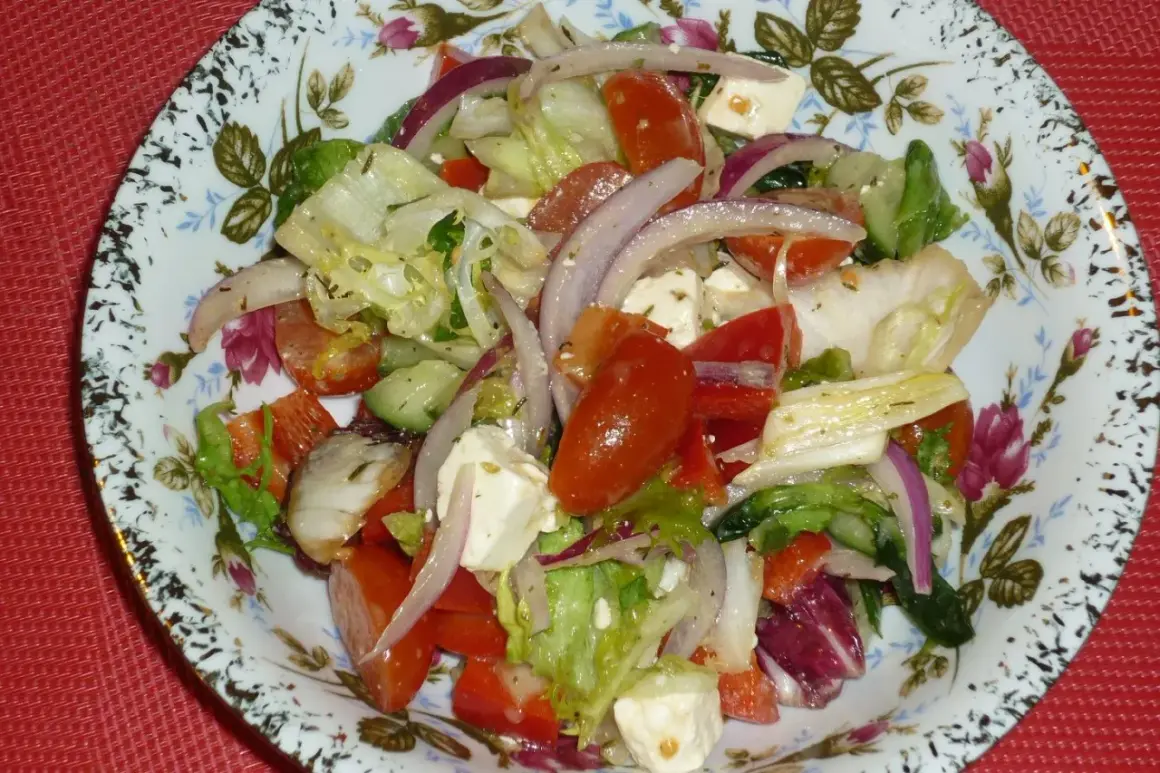Pyszna sałatka z mix sałat, pomidorów, ogórka, sera feta i czerwonej cebuli, doprawiona ziołami.