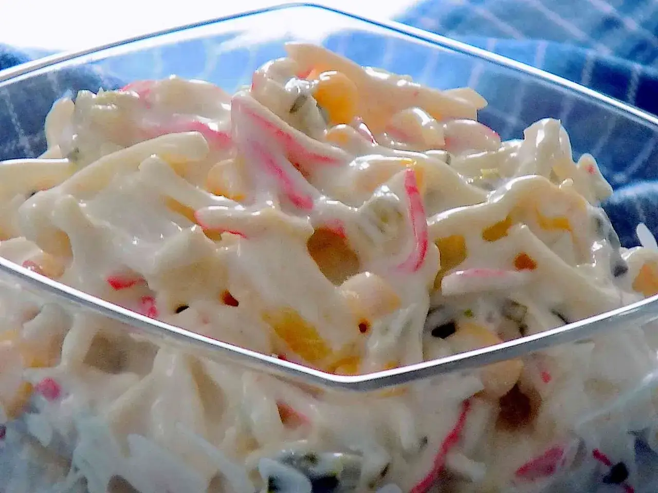 Pyszna sałatka z surimi, kukurydzą i majonezem w szklanej miseczce. Idealna na każdą okazję.
