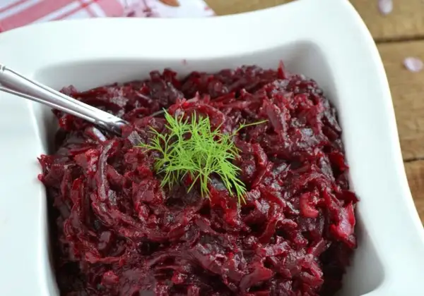 Pyszne, aromatyczne buraczki na ciepło, udekorowane gałązką koperku, podane w białej miseczce.